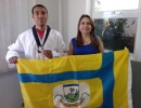 Márcio, a bandeira do Município e Maysa Cunha, secretária de assistência social e apoiadora