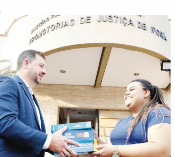 Promotor Sérgio de Sousa oferece livros de direito para fortalecer Nathália em seus estudos. Ela quer ser delegada (Foto de Lizi Dalenogari)